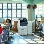 Xerox® VersaLink® B7100 serie, zwart-wit printer op de werkplek Team aan het werk in een open ruimte met de Xerox® VersaLink® B7100 serie zwart-wit printer