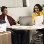 Xerox® C410 kleurenprinter op de werkplek Twee mensen in het kantoor naast de Xerox® C410 kleurenprinter