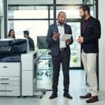 Twee mannen in een kantooromgeving die iets bespreken op een tablet naast een Xerox® AltaLink® C8200 Series Colour Multifunction Printer Twee mannen in een kantooromgeving die iets bespreken op een tablet naast een Xerox® AltaLink® C8200 Series Colour Multifunction Printer