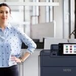 Een vrouw staat naast de Xerox® PrimeLink® C9200 Serie Printer in een moderne kantooromgeving Een vrouw staat naast de Xerox® PrimeLink® C9200 Serie Printer in een moderne kantooromgeving