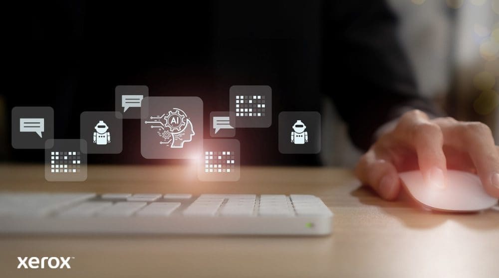 Xerox® DocuShare® Go: intelligent documentbeheer Iemands hand ligt op een computermuis en boven het toetsenbord zweven abstracte, oplichtende iconen die betrekking hebben op communicatie, kunstmatige intelligentie (AI) en gegevensverwerking. Deze iconen staan voor intelligente documentfunctionaliteiten.