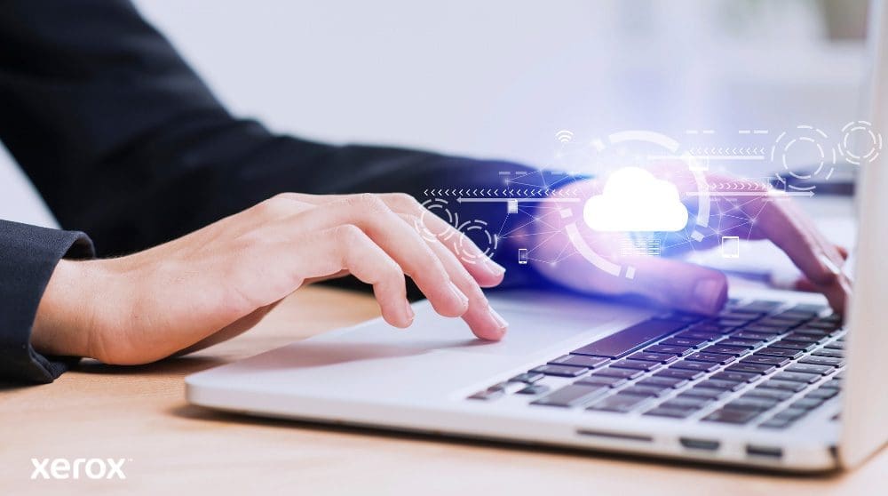 Xerox® Workplace Cloud en Suite: Cloudconnectiviteit Er worden iemands handen getoond die op een laptoptoetsenbord typen, met een gloeiend wolkpictogram en netwerkverbindingen over de afbeelding heen, wat symbool staat voor cloudconnectiviteit en digitale workflows.